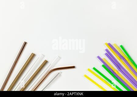 Opposizione di tubi monouso in plastica e metallo ambientale, vetro, bambù. Alternativa al concetto di vasellame usa e getta. Sfondo bianco. Orizzontale Foto Stock