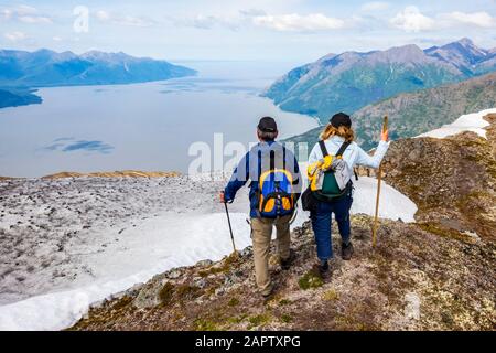 Escursionisti nelle montagne Chugach a sud di Anchorage, Alaska centro-meridionale. Estate. La coppia si affaccia su Turnagain Arm e sulla Seward Highway Foto Stock
