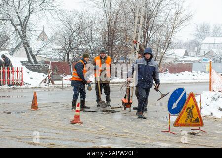 Città del servizio di emergenza di riparazione rottura tubo acqua in inverno. Foto Stock