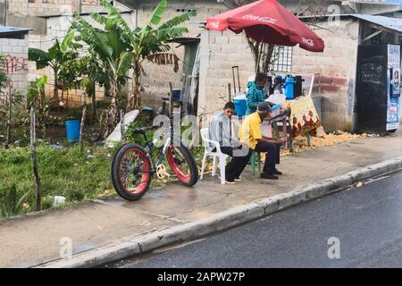Tre persone sulla strada in attesa di trasporto, Repubblica Dominicana Foto Stock
