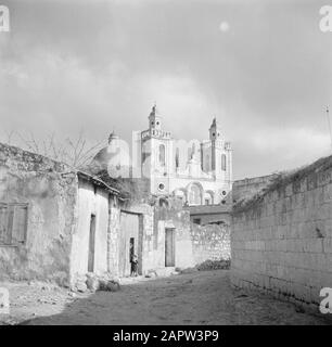 Israele 1948-1949: Kana Kana. Street visto in direzione della chiesa cattolica di nozze romana Annotazione: Il termine Chiesa di nozze si riferisce al miracolo che Gesù di Nazaret avrebbe fatto, trasformando l'acqua in vino durante il matrimonio di Cana Data: 1948 luogo: Israele, Cana Parole Chiave: architettura , immagini del villaggio, facciate, edifici della chiesa, torri della chiesa, cupole, neobarok Foto Stock