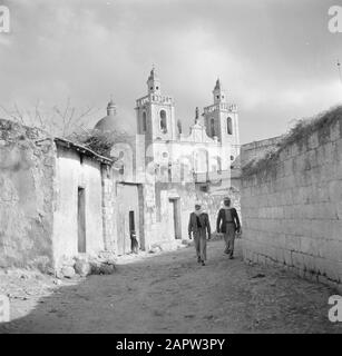 Israele 1948-1949: Kana Kana. Due uomini in una strada, visto in direzione della Chiesa di nozze Annotazione: Il termine Chiesa di nozze si riferisce al miracolo che Gesù di Nazaret avrebbe fatto, trasformando l'acqua in vino durante il matrimonio di Cana Data: 1948 luogo: Israele, Cana Parole Chiave: architettura, statue del villaggio, edifici della chiesa, torri della chiesa, cupole, neobarok Foto Stock