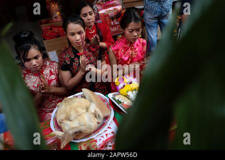 Una famiglia etnica cinese-tailandese presenta offerte agli antenati della famiglia e agli spiriti defunti mentre pregano per fortuna durante la celebrazione a Chinatown, Bangkok. Il nuovo anno lunare, conosciuto anche come Festival di primavera in Cina, segna l'inizio dell'anno del Rat. La famiglia etnica cinese-tailandese pregano per la buona fortuna e indossano maschere per la protezione dalle polveri mentre il paese lotta per contenere il peggioramento dell'inquinamento atmosferico. Foto Stock