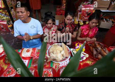 Una famiglia etnica cinese-tailandese presenta offerte agli antenati della famiglia e agli spiriti defunti mentre pregano per fortuna durante la celebrazione a Chinatown, Bangkok. Il nuovo anno lunare, conosciuto anche come Festival di primavera in Cina, segna l'inizio dell'anno del Rat. La famiglia etnica cinese-tailandese pregano per la buona fortuna e indossano maschere per la protezione dalle polveri mentre il paese lotta per contenere il peggioramento dell'inquinamento atmosferico. Foto Stock