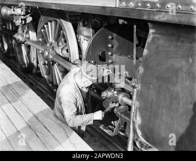 Reportage Nederlandse Spoorwegen Engineer esegue la manutenzione su una locomotiva Data: 1932 posizione: Amsterdam, Noord-Holland Parole Chiave: Operatori, manutenzione, ferrovie, locomotive a vapore Foto Stock