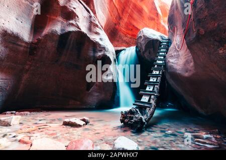 Lunga esposizione della cascata che scorre sul gradino di roccia nel canyon della fessura Foto Stock