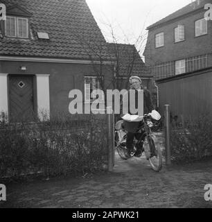 Giornata nella vita della famiglia Svendsen Svendsen Svendsen in bicicletta con motore ausiliario sul percorso del giardino della sua casa Data: Marzo 1954 luogo: Danimarca Parole Chiave: Vita quotidiana, biciclette, moto , giardini, donne, case Nome personale: Svendsen, Foto Stock