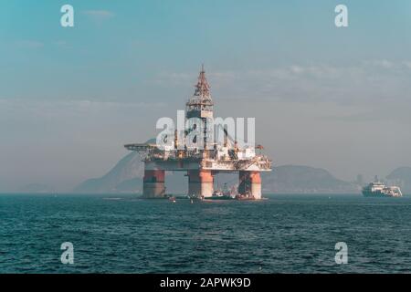 Piattaforma di estrazione dell'olio nel mare circondata da colline Rio De Janeiro in Brasile Foto Stock