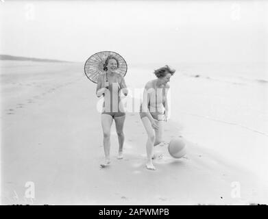 Modello di Reportage Eva Waldschmidt (con ombrellone) e Van de Polls donna nell Langlais camminare lungo la linea di marea a Zandvoort Data: 1932 posizione: Noord-Holland, Zandvoort Parole Chiave: Spiagge Nome personale: Langlais, Nell, Waldschmidt, Eva Foto Stock