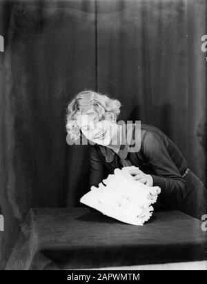 Modello di Reportage Eva Waldschmidt dietro una pila di biancheria Data: 1932 Parole Chiave: Modelli fotografici, lavanderia Nome personale: Waldschmidt, Eva Foto Stock