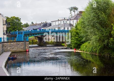 21 agosto 2019 il lento fiume che scorre Kesh che scorre sotto il ponte ad arcate in Kesh villaggio su un ottuso wet giorno d'estate. Foto Stock