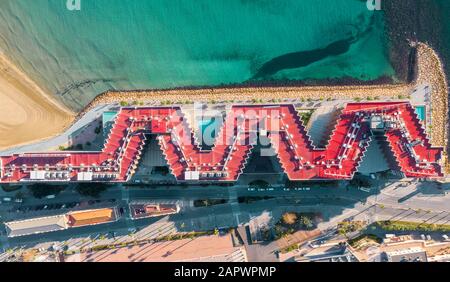 Tetto rosso che forma una W forma nel porto di Alicante Spagna circondato da acque turchesi Foto Stock