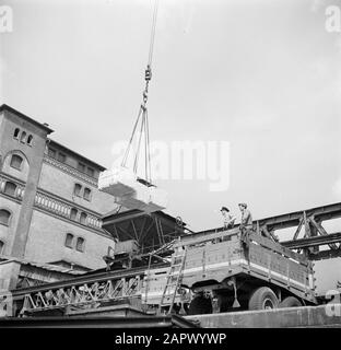 Navigazione sul Reno, rapporto della nave a motore Damco 230: Germania occidentale Trasbordo di merci in camion nel porto di Karlsruhe Data: 1 aprile 1955 Ubicazione: Germania, Karlsruhe, Germania occidentale Parole Chiave : porti, gru, carico e scarico, skipper, camion Foto Stock
