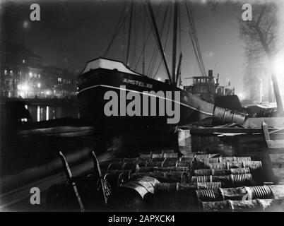 Sculture della città di Amsterdam, foto notturne nave Amstel II, con barili sul molo, sulla Amstel di notte; Teatro di sinistra Carré Data: 1935 posizione: Amstel, Amsterdam, Noord-Holland Parole Chiave: Notte, navi, sculture della città, teatro Foto Stock