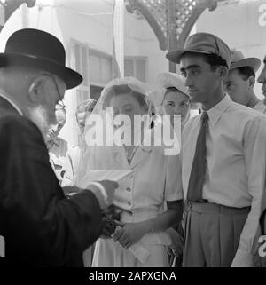 Israele 1948-1949: Matrimoni a Lag BaoMer Soldier e la sua sposa durante la cerimonia di nozze, presumibilmente in Haifa Annotazione: Lag BaoMer (anche Lag Baomer, Lag BaoMer, Lag B'Omer) è un giorno di tradizionalmente molti matrimoni sono conclusi Data: 1948 posizione: Haifa, Israele Parole Chiave: Clero, cerimonie di nozze, religione ebraica, rabbini, rituali, veli Foto Stock