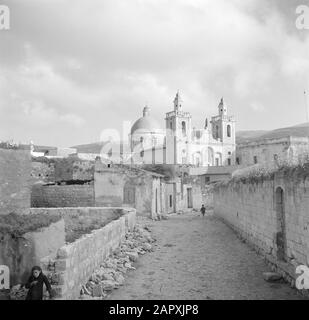 Israele 1948-1949: Via Kana visto in direzione della chiesa cattolica di nozze romana Annotazione: Il termine Chiesa di nozze si riferisce al miracolo che Gesù di Nazaret avrebbe fatto, dove durante il matrimonio di acqua Kana trasformato in vino Data: 1948 luogo: Israele, Kana Parole Chiave: immagini del villaggio, edifici della chiesa, strade, torri Foto Stock