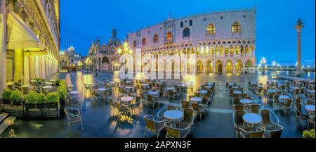 Ristorante in Piazza San Marco con Palazzo Ducale di notte, inondato di acqua alta, panorama, Venezia, Italia Foto Stock