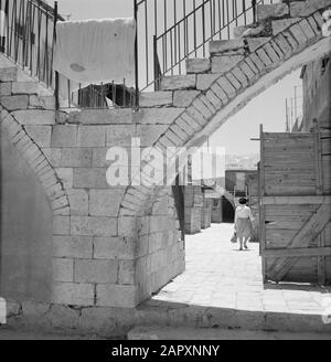 Israele 1964-1965: Gerusalemme (Gerusalemme), Mea Shearim Scale su archi che formano le viste alle case dietro Annotazione: MEA Shearim, chiamato anche Meah Shearim o un centinaio di porte, è uno dei quartieri più antichi di Gerusalemme. Fu costruito a partire dal 1870 da ebrei asiatici che vivevano nella Città Vecchia fino ad allora. Tuttavia, c'era troppo poco spazio e così comprarono un pezzo di terra a nord-ovest della città. Questa terra, un'area paludata, fu coltivata in terra per costruire un nuovo quartiere: Meah Shearim. Il distretto è noto anno 2012 come il quartiere ebraico ortodosso più estremo del mondo ed è la casa di s. Foto Stock