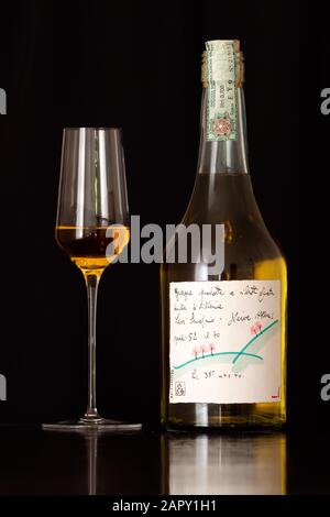 Neive, Alba, Italia - 12 gennaio 2020: Bottiglia originale della Grappa di Romano Levi con disegno dal 1995 con un bicchiere di liquore su sfondo scuro. Foto Stock