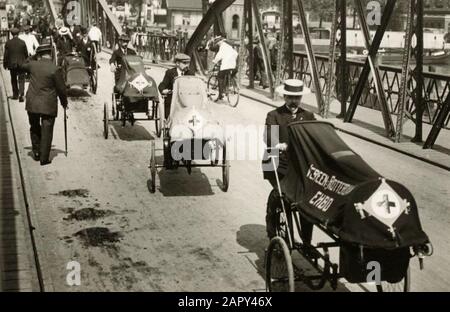 Prima guerra mondiale Attraverso un ponte, una parata intera dei dipendenti della Croce Rossa si muove su biciclette con carrelli di bicicletta di fronte a loro, che può essere trasportato ferito. Uno di loro dice, Verone. Primo soccorso a Rotterdam. Rotterdam, Paesi Bassi, 1914. Foto Stock