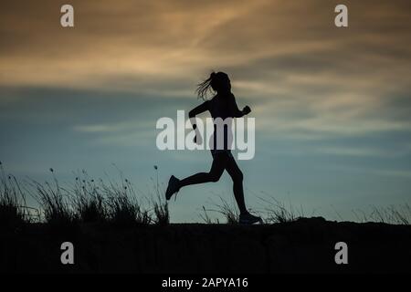 Atleta runner che corre su pista. Donna fitness jogging allenamento benessere concetto. Foto Stock