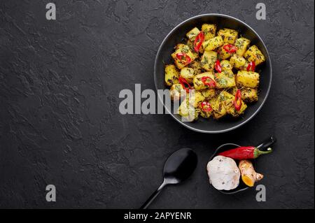 Aloo Methi in rame kadai, ciotola su fondo di ardesia scura. Aloo Methi è un piatto di cucina indiana con patate, Fenugreek e spezie. Cibo Indiano. Copia spac Foto Stock