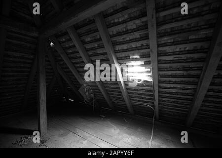 All'interno della soffitta di una vecchia casa con ragnatele. Bianco e nero. Foto Stock