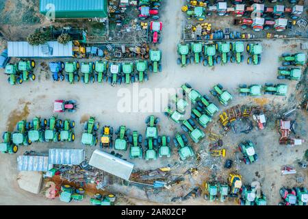Vista aerea dall'alto verso il basso dei trattori verdi che formano una curva a Belmonte Spagna in un gennaio di congelamento Foto Stock