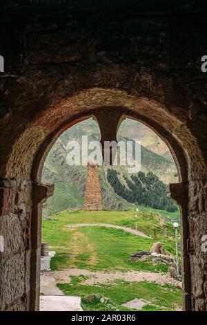 Sioni, Georgia. Antica Torre Di Avvistamento Di Pietre Antiche Sullo Sfondo Delle Montagne Nel Villaggio Di Sioni, Nel Distretto Di Kazbegi, Nella Regione Di Mtskheta-Mtianeti, In Georgia. Molla O S. Foto Stock