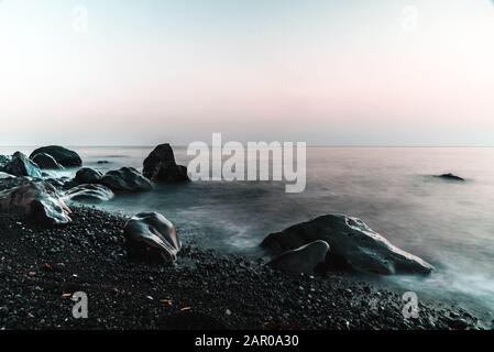 Tramonto sull'oceano con foto a lunga esposizione Foto Stock