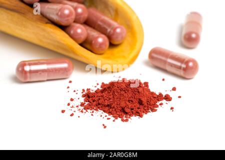 Riso di lievito rosso o angkak o polvere di riso kojic e capsula supplementare su sfondo bianco isolato Foto Stock