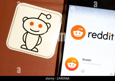 Los Angeles, California, Stati Uniti - 22 gennaio 2020: Logo Reddit app e telefono con icona primo piano su sfondo marrone, Editoriale Illustrativo Foto Stock