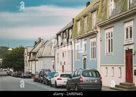 Alesund, Norvegia - 19 Giugno 2019: Auto Parcheggiate Vicino A Vecchie Case Di Legno Nel Nuvoloso Giorno Estivo. Foto Stock