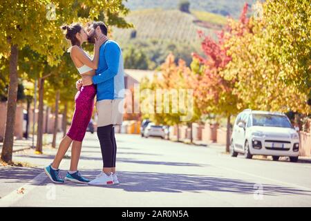 Giovane coppia sul jogging godendo insieme e baciare Foto Stock