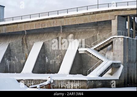 Diga in cemento con scala coperta di neve. Foto Stock