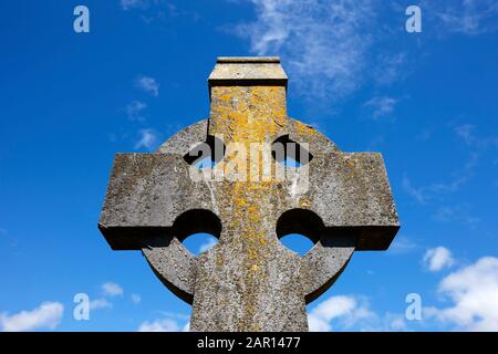 Pietra irlandese croce celtica croce lapidi memoriale contro un cielo blu nuvoloso in irlanda Foto Stock