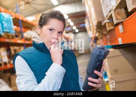 lavoratore di magazzino femminile che tiene scanner Foto Stock