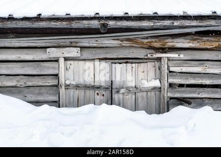 Vecchia porta fienile in legno con neve Foto Stock