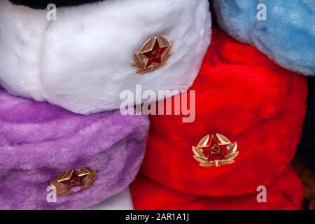 Cappellini in pelliccia con stelle rosse nel negozio di souvenir di Mosca Street. Cappelli invernali, divisa militare sovietica e russa, in viaggio verso la Russia, gi turistica Foto Stock
