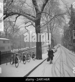 Donna con ombrello nella neve alle otto del mattino camminando lungo il Prinsengracht ad Amsterdam Data: 27 novembre 1965 Località: Amsterdam, Noord-Holland Parole Chiave: Biciclette, canali, canali, neve, neve, sculture della città Foto Stock