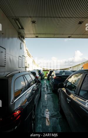 Automobili trasportate su uno dei traghetti dell'automobile fra Mortavika e Arsvågen in un giorno luminoso, la Norvegia Foto Stock