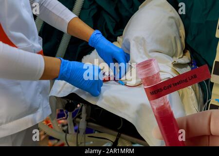 Sindrome respiratoria del Medio Oriente coronavirus infezione cinese i chirurghi e gli assistenti si preparano per la chirurgia in una sala operatoria preparando un paziente fo Foto Stock