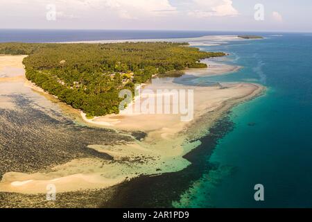 Un cordone sabbioso con palme da cocco e alcune case si protende nelle acque turchesi della laguna al largo di Buka Island, Papua Nuova Guinea. Foto Stock