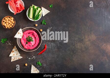 Hummus rosso Coleotteri, sano bagno vegano. Hummus tradizionale della barbabietola mediorientale, spalmato con pane pita e verdure. Vista dall'alto, spazio di copia. Foto Stock