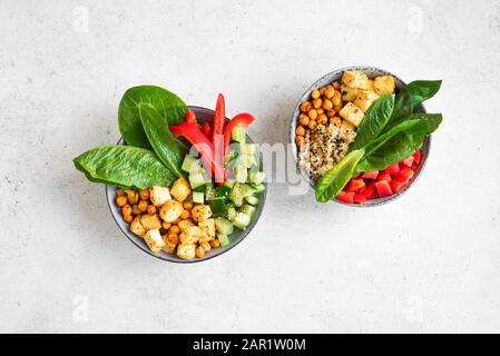 Insalata Di Tofu Fritta Con Cetrioli, Ceci Fritti, Foglie Di Verdure E Semi Di Sesamo. Insalata vegana bilanciata colorata per un pranzo sano in ciotola di ceramica, Foto Stock