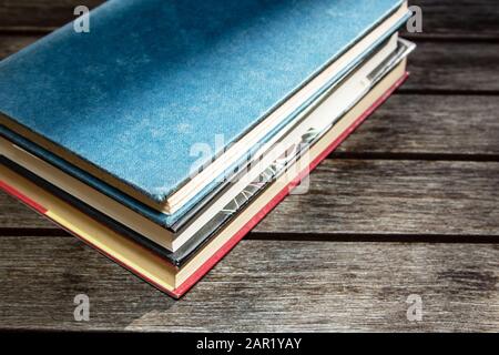 High Angle shot di tre libri spessi su un legno superficie Foto Stock