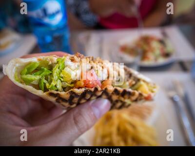 Persona che tiene un panino con polpette di carne - cibo tradizionale turco Foto Stock