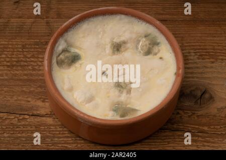 una ciotola di yogurt ammuffito su un tavolo di legno Foto Stock