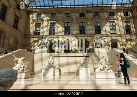 Un visitatore che scatta foto nel cortile della scultura Cour Marly nell'ala Richelieu del Museo del Louvre (Musée du Louvre) a Parigi, Francia Foto Stock