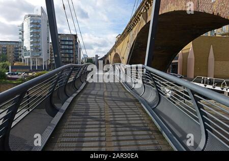 Moderno ponte pedonale con doghe in legno a Limehouse Basin, nella parte orientale di Londra, Regno Unito Foto Stock